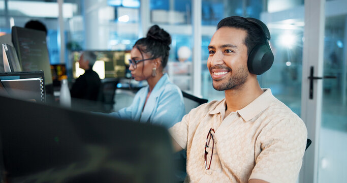 Office, businessman and headphones with computer for web development, coding and listening to music. Coworking, night and male programmer with technology for programming, software update and podcast