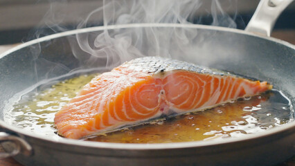 Sizzling Salmon Steak: Close-up of a fresh salmon fillet cooking in a hot pan. Steam rising, creating a mouth-watering experience. This culinary creation showcases delicious and healthy eating.