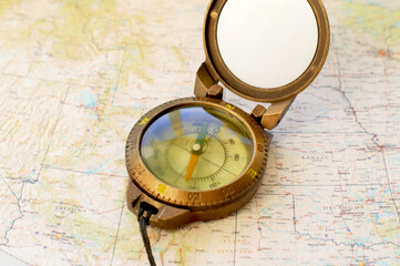 Army compass lies on an old physical map