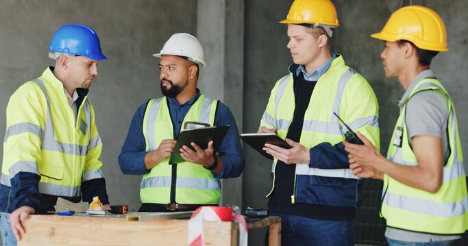Man, checklist and group at construction site for meeting, review and planning for renovation project. Lead engineer, clipboard and team for advice, listen or problem solving for property development