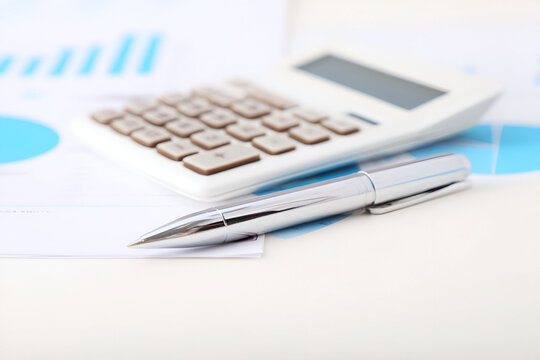 Analysis of business data with calculator and pen on financial documents
