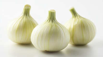 Obraz premium Still life of three fresh white onions on a clean white surface, a culinary harmony