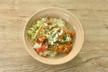 deep fried slicechicken dressing cream sauce with Japanese pickled vegetable and slice cabbage on rice in bowl 