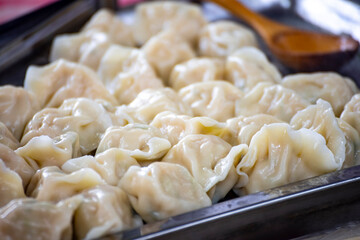 a stall is filled with steaming hot dumplings