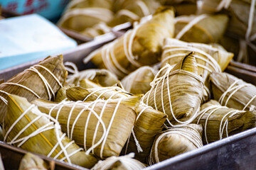 a container is filled with traditional zongzi wrapped in bamboo leaves and tied with string