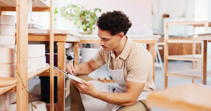 Man, writing and clipboard at pottery workshop for cup inspection, review notes and stock checklist. Potter, document and quality check, inventory management and sculpture price for order information - Powered by Adobe