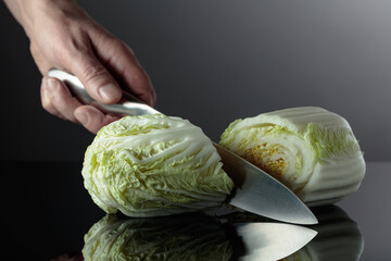 Hand with knife and cut Chinese cabbage.