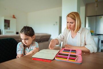 Learning moment between mother and daughter at home