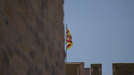 The flag of the Aragon region waving in the wind, captured in 4K slow motion against a clear blue sky