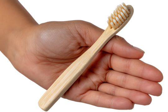 Hand holding bamboo toothbrush on white background for eco-friendly oral care.