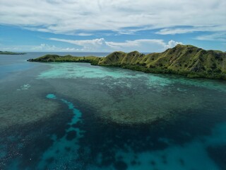 Aerial view A phinisi boat is sailing carrying tourists who will visit the islands around the waters of Labuan Bajo, East Nusa Tenggara, Indonesia.