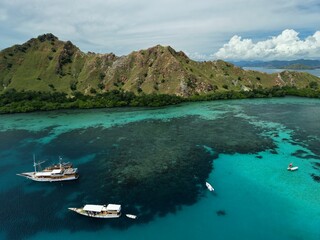 Aerial view A phinisi boat is sailing carrying tourists who will visit the islands around the waters of Labuan Bajo, East Nusa Tenggara, Indonesia.