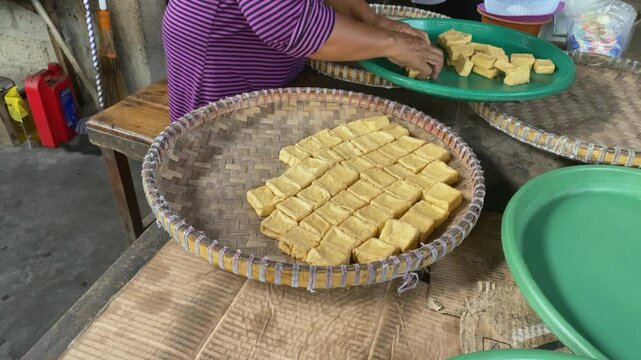 hands stacking tofu on a tray at Traditional tofu factory