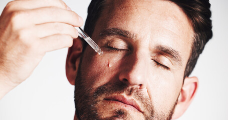 Serum, beauty and glow with man in studio for skincare treatment, anti aging benefits and hydration. Collagen, shine and oil dropper with mature person on white background for cosmetics and self care