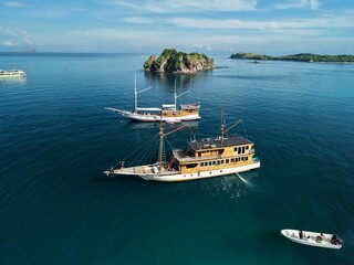 Aerial view A phinisi boat is sailing carrying tourists who will visit the islands around the waters of Labuan Bajo, East Nusa Tenggara, Indonesia.