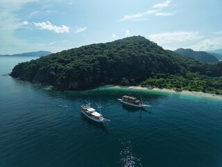 Aerial view A phinisi boat is sailing carrying tourists who will visit the islands around the waters of Labuan Bajo, East Nusa Tenggara, Indonesia.