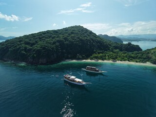 Aerial view A phinisi boat is sailing carrying tourists who will visit the islands around the waters of Labuan Bajo, East Nusa Tenggara, Indonesia.