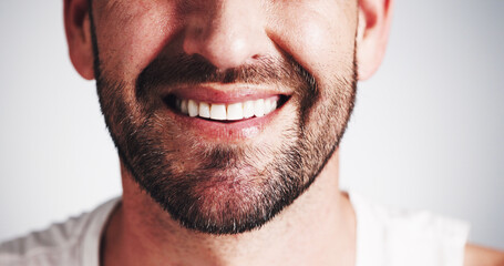 Fototapeta premium Dentistry, mouth and smile of man in studio closeup for dental health, oral hygiene or teeth whitening. Aesthetic, beard and veneers implant with happy person on white background for tooth care