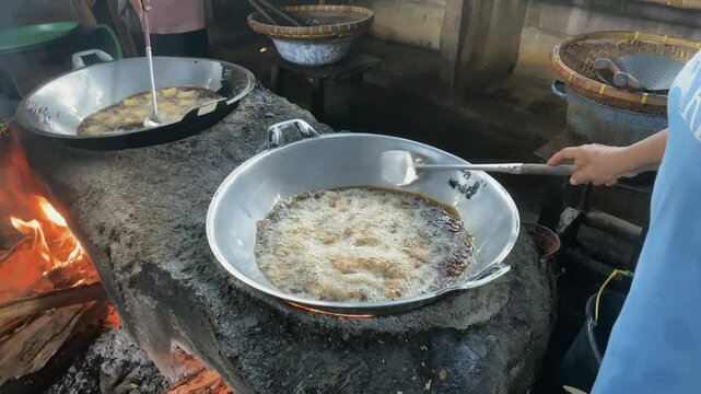 The process of frying tofu in a traditional tofu factory using a traditional stove