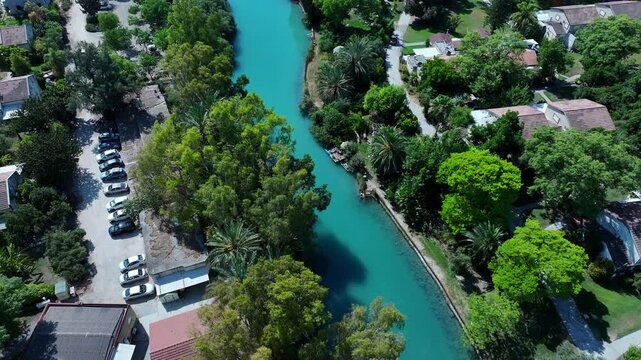 Aerial Upward Shot Of Asi River Stream Flowing Amidst Houses In Kibbutz Community Settlement - Nir David, Israel