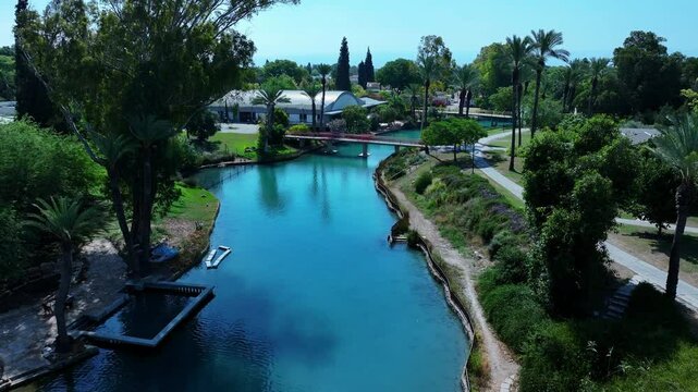 Aerial: Scenic View Of Kibbutz Residential District, Drone Flying Forward Over River Stream On Sunny Day - Nir David, Israel