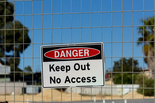 Danger no access sign on mesh fence