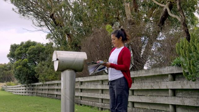 Woman checking mail at a rural mailbox