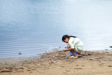 A girl enjoys playing and collecting shells on a summer beach.