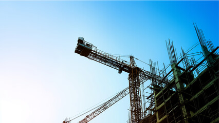 Tower Crane and Building Framework at Construction Site Against Clear Blue Sky