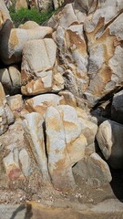 A close-up view of several light-colored, weathered rocks and boulders with tan markings on the...