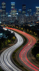 Obraz premium City Lights & Highway Streams: Nightscape of Urban Flow | Time-Lapse Photography of Car Trails & Skyline