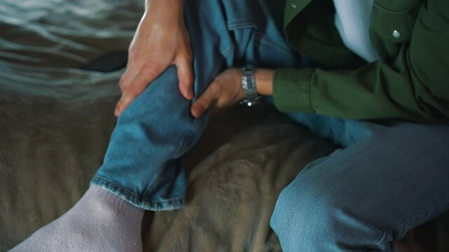 Close-up massage of a sore leg.
Injured male leg in blue jeans.
Leg pain.
A man limps while walking.
Strained muscles in the leg.
Bruise on leg