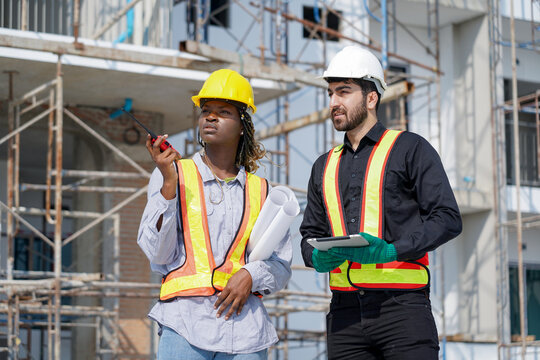 group of diversity meeting construction  worker latin engineer talking to african american Architects woman inspection and Quality control at Construction site outdoors. builder discussion