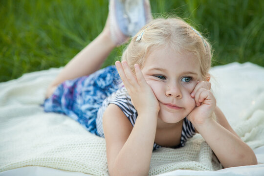 Bored little girl resting face in hands outside