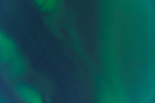 Vivid green aurora borealis over starry sky