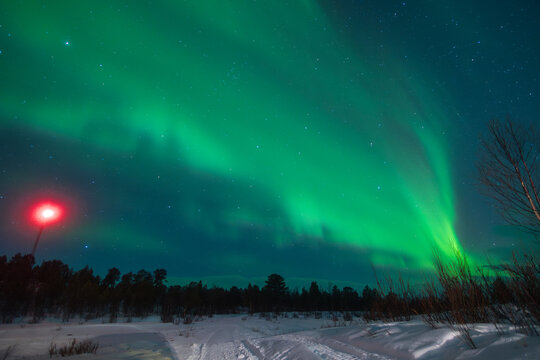Stunning Aurora borealis display over snowy landscape in Sweden
