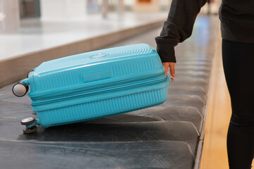 Blue suitcase on airport baggage carousel