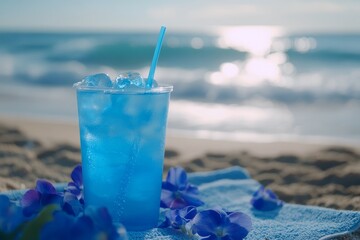 Obraz premium Vibrant blue beverage on beach towel with ice cubes.