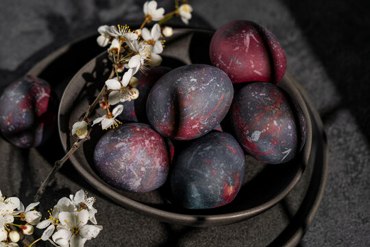 Dark and artistic display of Easter eggs with spring blossoms