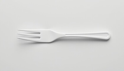 A single white fork isolated against a seamless backdrop. The fork appears clean and unused, with a minimalist design.