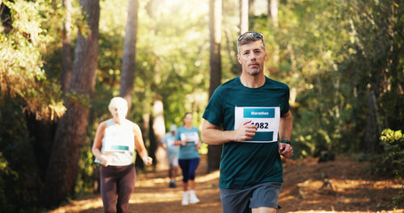 Obraz premium Action, marathon and running with man in forest for challenge, performance or race. Competition, cardio and fitness with mature runner at rally event in nature or woods for course, heat or trial
