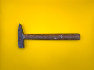 Rusty hammer on yellow background. Builder Tool. Flat lay. Top view, copy space.