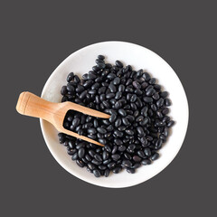 A raw black beans on wooden spoon  , Food ingredient.