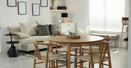 Table, chairs and comfortable sofa indoors. Interior design