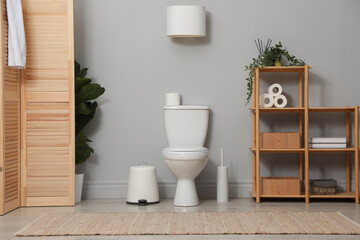 Ceramic toilet bowl, brush and necessities in restroom