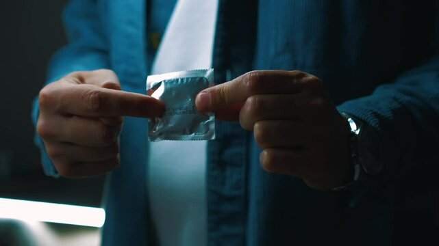 The man shows with his hand where to put on the preventative.
A man points his finger at the genitals and indicates that a condom should be used.
Contraception method.
Sex, diagnosis, infection, pregn