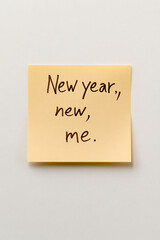 Inspirational New Year's message, a yellow note reads "New year, new, me," expressing self-renewal and fresh starts.