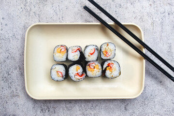 some pieces of sushi on a plate with chopsticks