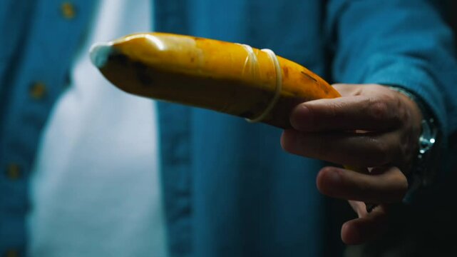 A man with a banana and a condom shows how to protect himself from unwanted pregnancy and sexually transmitted infections.
Aborted pregnancy.
Safe sex.
Intimacy, pregnancy, abortion, sex