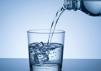 Invigorating water flow into a clear glass with icy vibes, ideal for a wellness indoor setting
